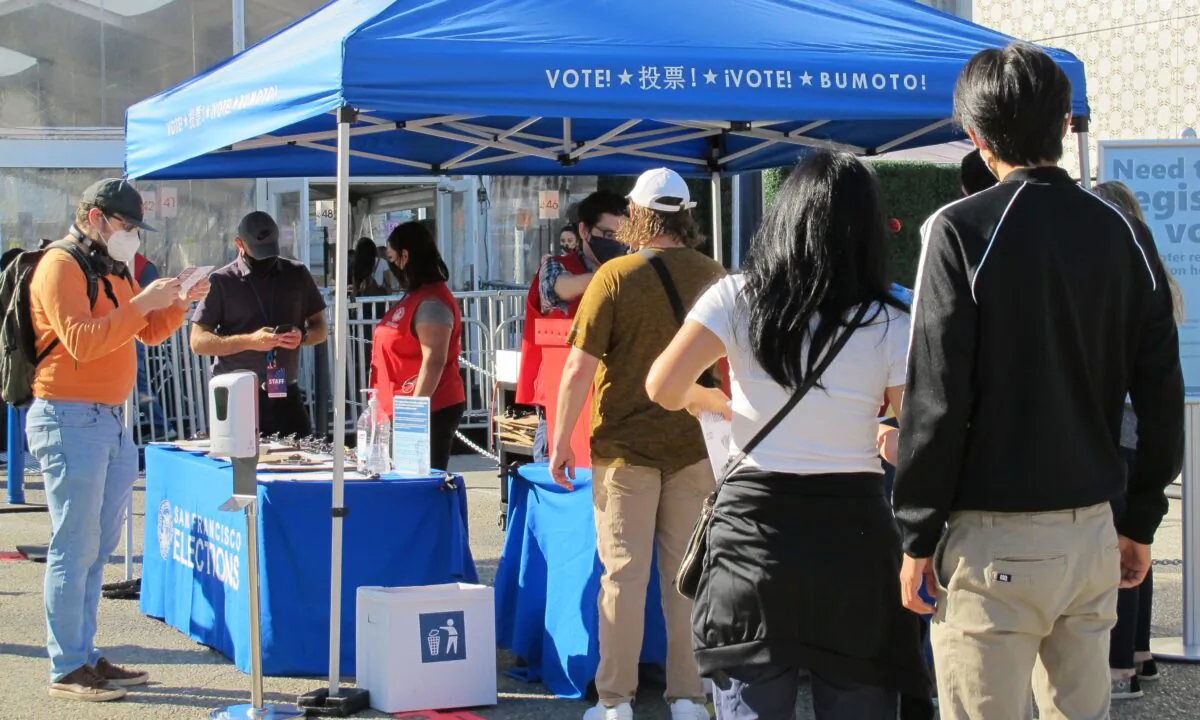 People drop off their ballots at a booth near the Bill Graham Civic Auditorium in San Francisco on Oct. 31, 2020. (Ilene Eng/The Epoch Times)