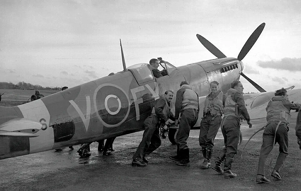 The aircrew of 611 West Lancashire Squadron push a Spitfire at Biggin Hill, England, in late 1942. (Public domain)