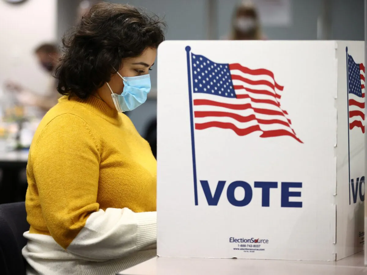 A woman fills in a ballot at the Fairfax County Government Center during the 2020 presidential election in Fairfax, Va., on Nov. 3, 2020. (Hannah McKay/Reuters)