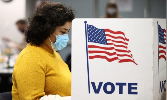 A woman fills in a ballot at the Fairfax County Government Center during the 2020 presidential election in Fairfax, Va., on Nov. 3, 2020. (Hannah McKay/Reuters)