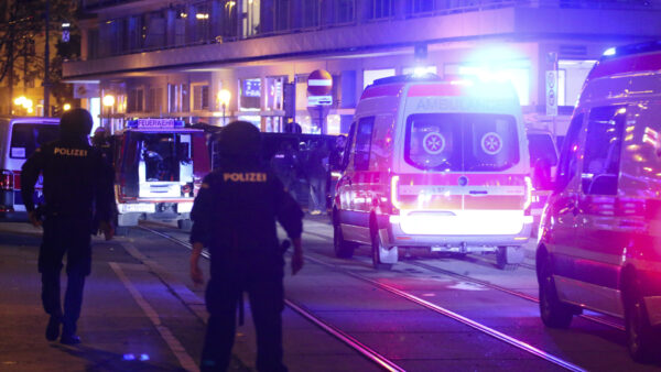 A police officers walk near ambulances