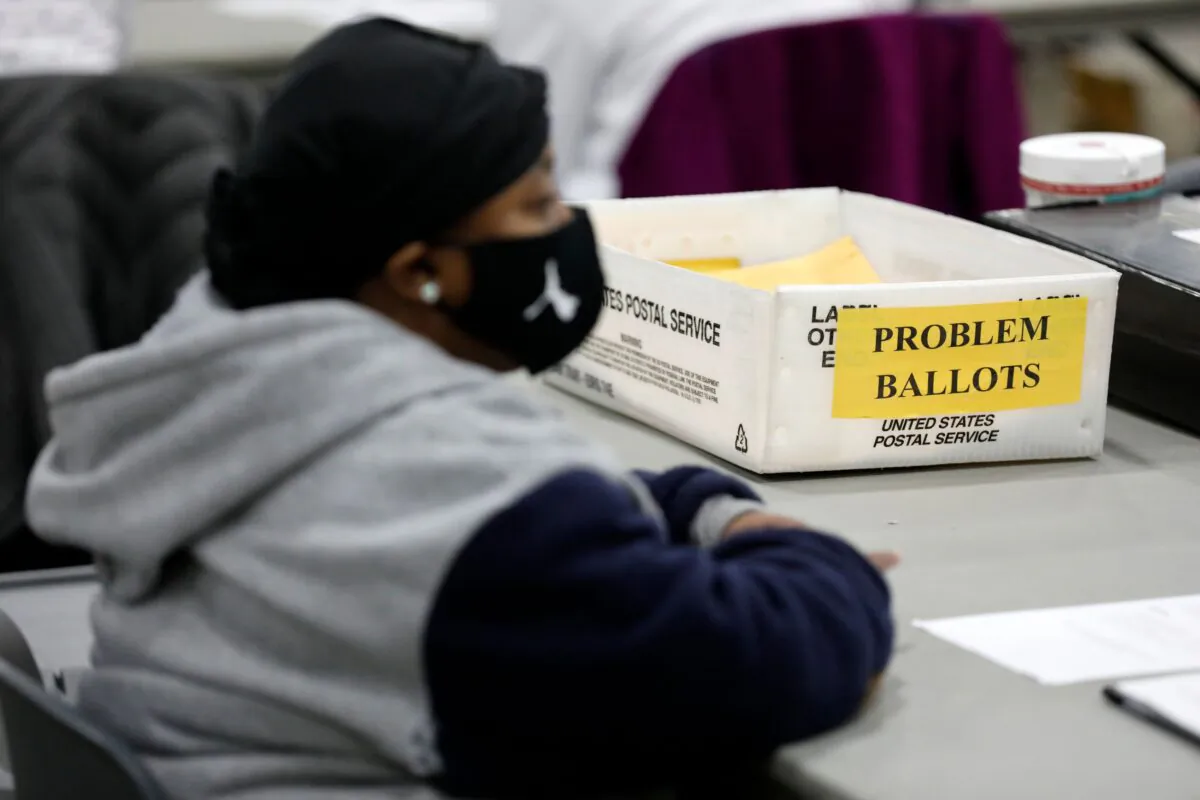 An election worker waits to receive absentee ballots to check they are properly filled out for the general election at TCF Center in Detroit, Michigan, on Nov. 3, 2020. (JEFF KOWALSKY/AFP via Getty Images)