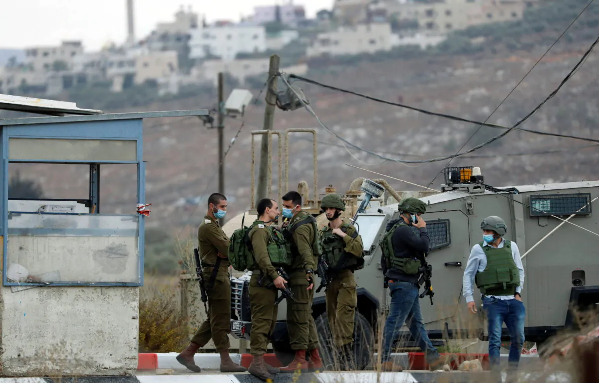 Members of Israeli forces gather at the scene of an incident at the Hawara checkpoint near the Palestinian city of Nablus, in the Israeli-occupied West Bank, on Nov. 4, 2020. (Mohamad Torokman/Reuters)
