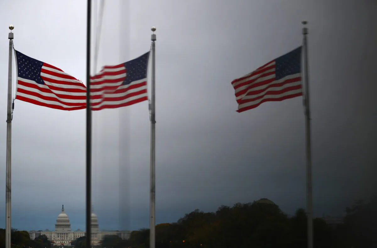 The United States Capitol and U.S flags are reflected in a window in Washington on Oct. 29, 2020. (Hannah McKay/Reuters)