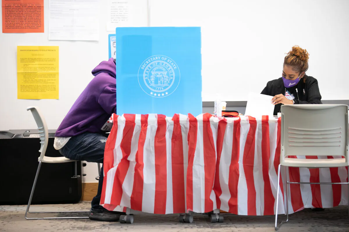 Sitting next to a poll worker, a Fulton County voter casts a ballot at the Metropolitan Library in Atlanta, Ga., on Nov. 3, 2020. (Jessica McGowan/Getty Images)