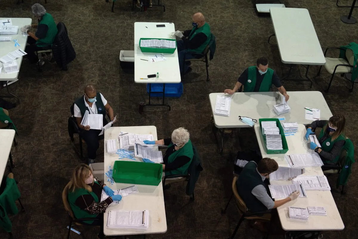 Poll workers review voter ballots at the Denver Elections Division headquarters in Denver, Colo., on Nov. 3, 2020. (Jason Connolly/AFP via Getty Images)
