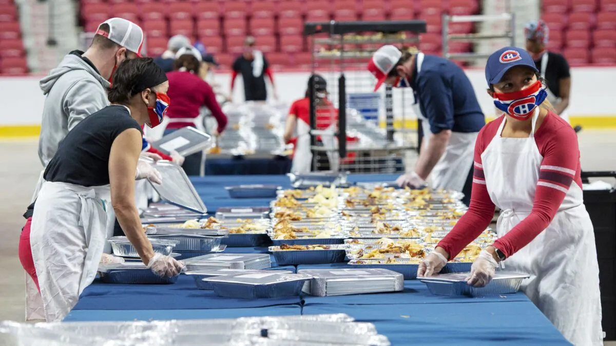 Volunteers prepare meals for food banks on the floor of the Bell Centre in Montreal on May 5, 2020. (The Canadian Press/Ryan Remiorz)