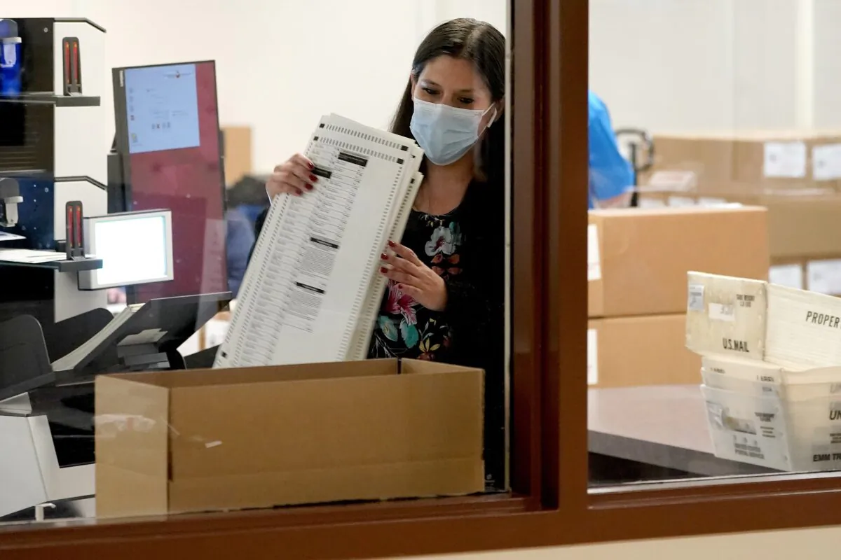 Maricopa County elections officials count ballots behind boxes of counted ballots at the Maricopa County Recorders Office in Phoenix, Ariz., on Nov. 4, 2020. (Matt York/AP Photo)