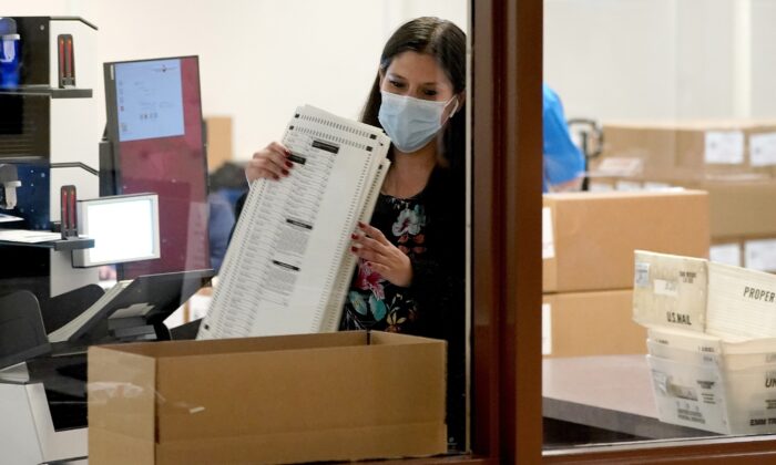 Maricopa County elections officials count ballots behind boxes of counted ballots at the Maricopa County Recorders Office in Phoenix, Ariz., on Nov. 4, 2020. (Matt York/AP Photo)