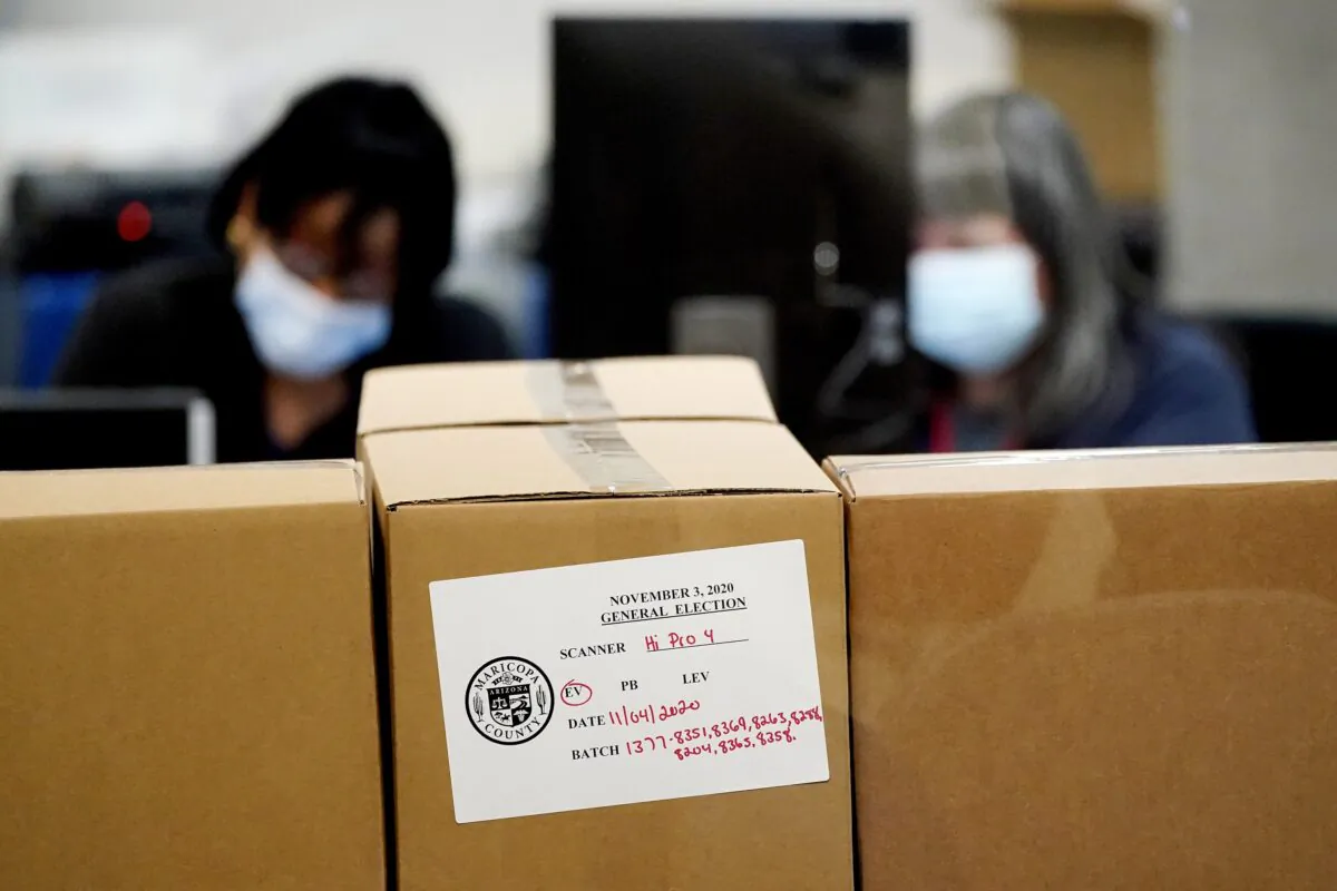 Maricopa County elections officials count ballots behind boxes of counted ballots at the Maricopa County Recorders Office in Phoenix, Ariz., on Nov. 4, 2020. (Matt York/AP Photo)