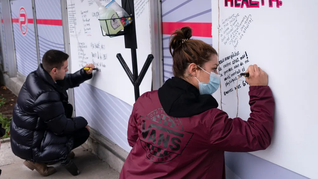 Clients each write a comment on the outside wall of a gym during a morning protest in Montreal, on Oct. 29, 2020. (The Canadian Press/Paul Chiasson)