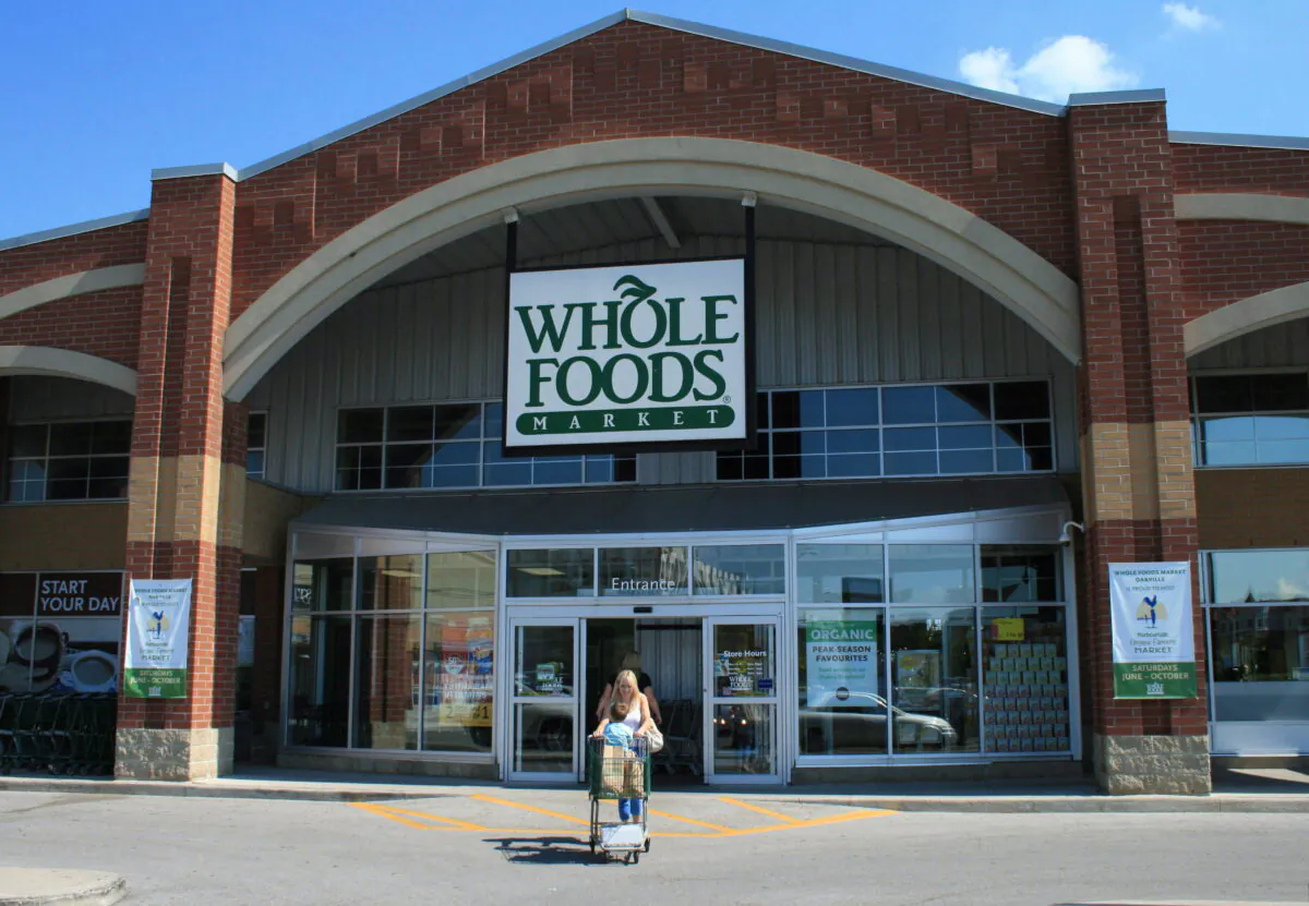 A customer leaves a Whole Foods Market store in Oakville, Ont., Canada on Aug. 22, 2012. (Richard Buchan/The Canadian Press)
