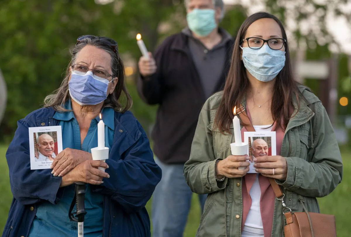 People participate in a vigil for COVID-19 victims at the Orchard Villa long-term care home in Pickering, Ont. on June 15, 2020. (The Canadian Press/Frank Gunn)