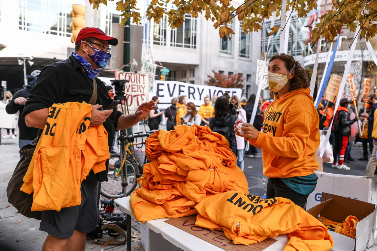 The Working Families Party hands out yellow “Count Every Vote” hoodies by the Pennsylvania Convention Center in Philadelphia, Pa., on Nov. 6, 2020. (Charlotte Cuthbertson/The Epoch Times)