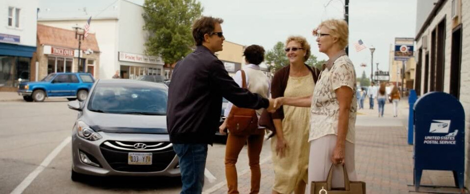 man in sunglasses shakes hands with woman in "Heaven is for Real"