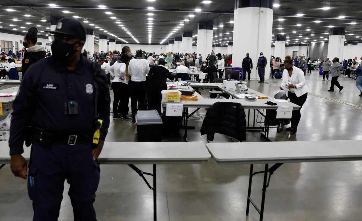 A Detroit Police officer stands guard as Detroit election workers work on counting absentee ballots for the 2020 general election at TCF Center in Detroit, Mich., on Nov. 4, 2020. (Jeff Kowalsky/AFP via Getty Images)