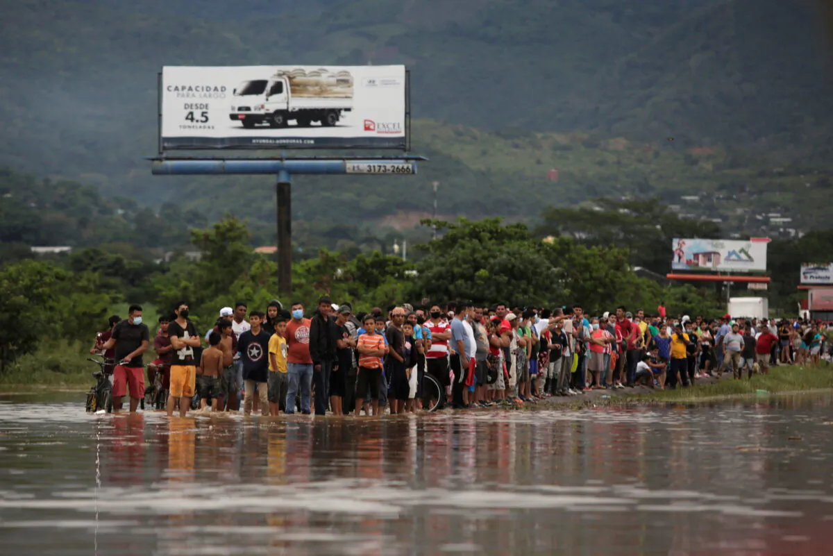 People look at a flooded street during the passage of Storm Eta, in Pimienta, Honduras on Nov. 5, 2020. (Jorge Cabrera/Reuters)