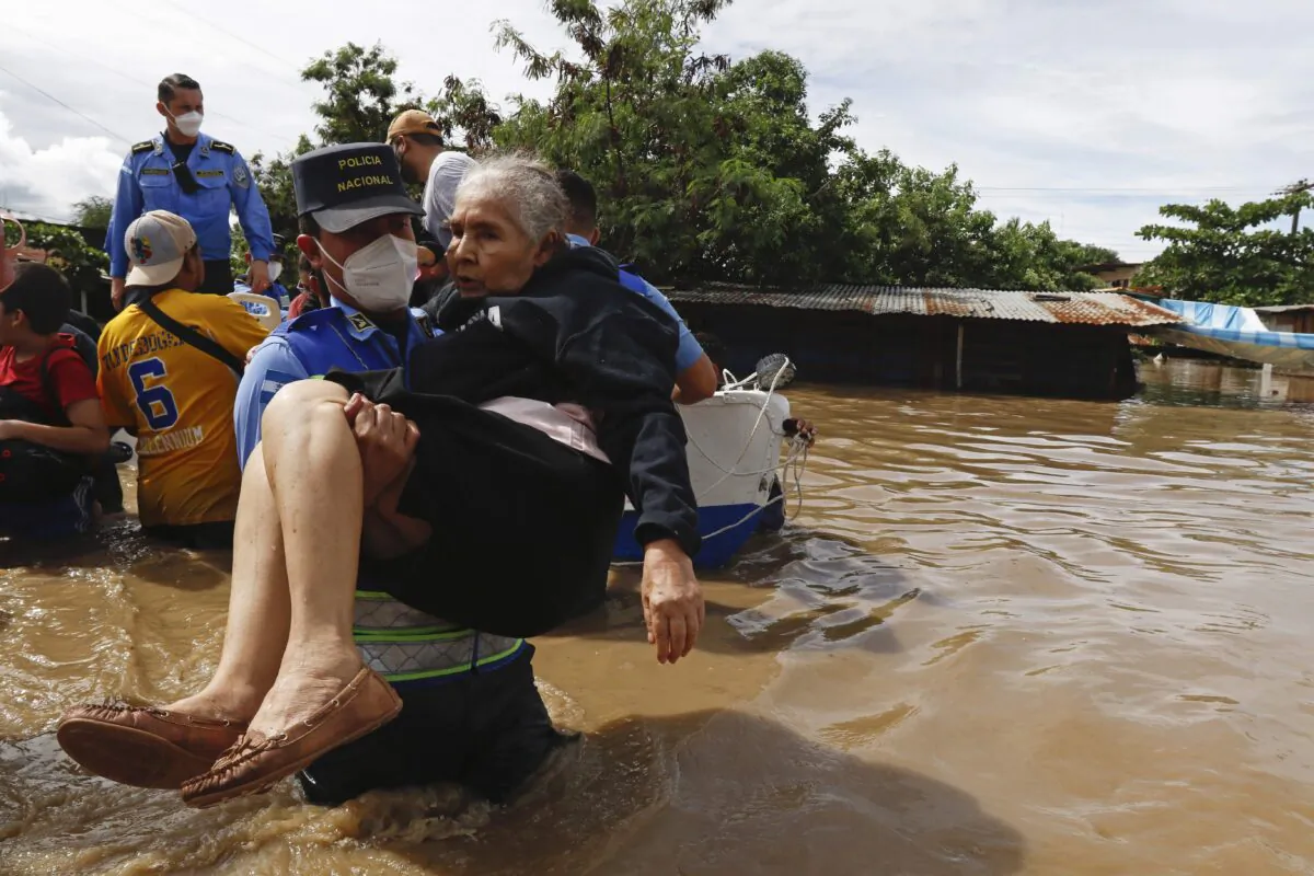 A woman is helped out of a flooded area in neighborhood of Jerusalen, Honduras, on Nov. 5, 2020. (Delmer Martinez/AP Photo)
