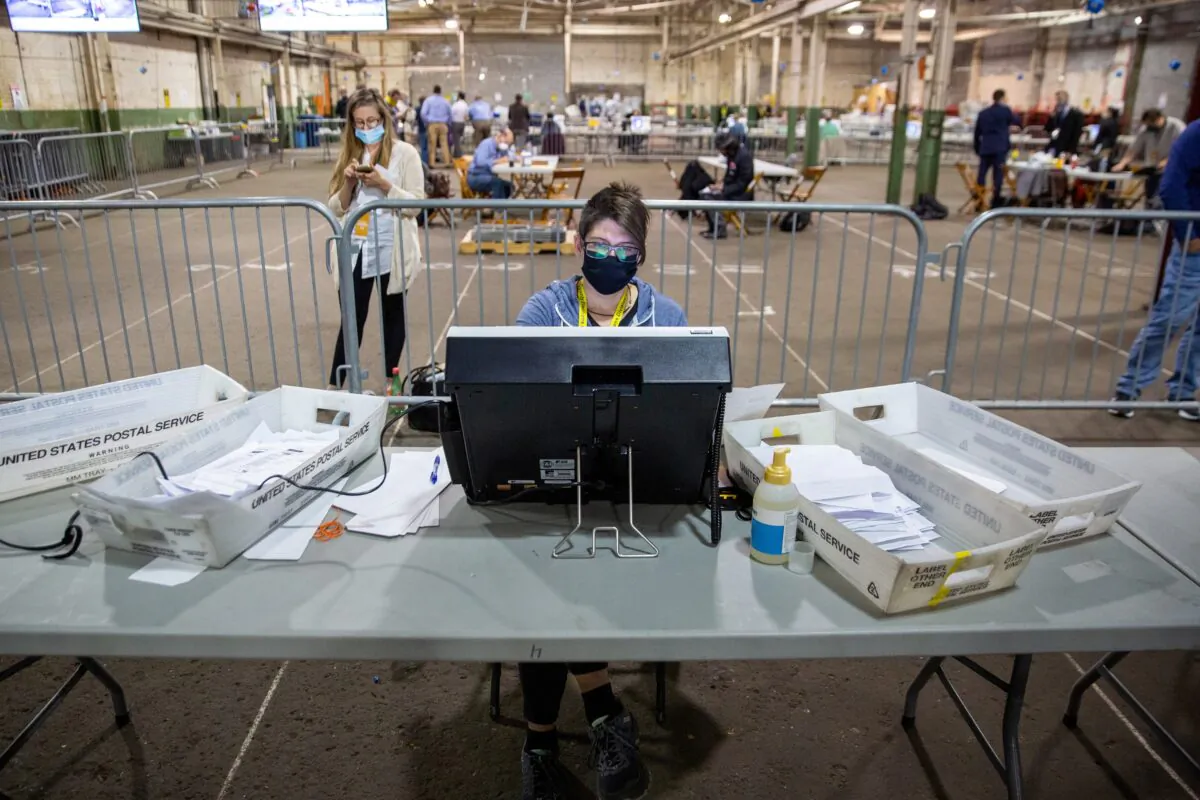 An observer watches a poll worker tabulate ballots at the Allegheny County Election Warehouse after the election in Pittsburgh, Pa., on Nov. 6, 2020. (John Altdorfer/Reuters)