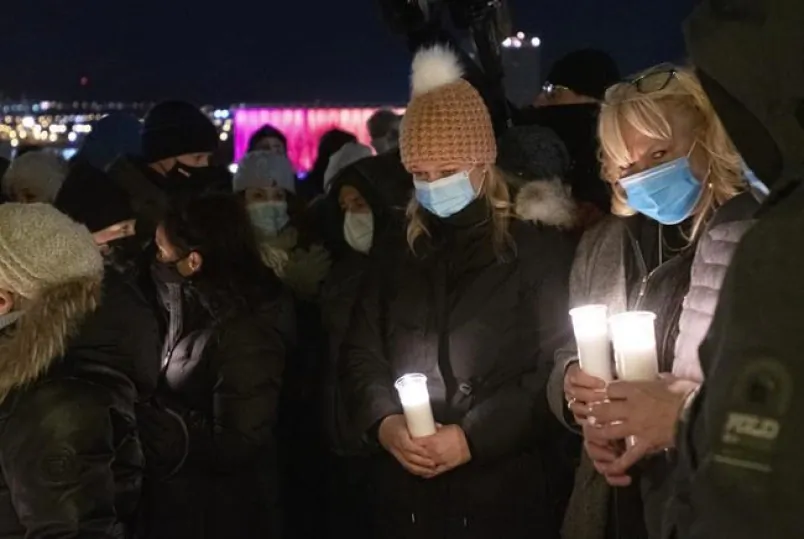 Neighbour Marie-France Rioux, left, holds a candle at a vigil to honour Suzanne Clermont who was stabbed to death on Halloween night by a man with a sword, on November 2, 2020 in Quebec City. Quebec City residents have launched an online petition seeking a space be named for stabbing spree victim Suzanne Clermont. (The Canadian Press/Jacques Boissinot)