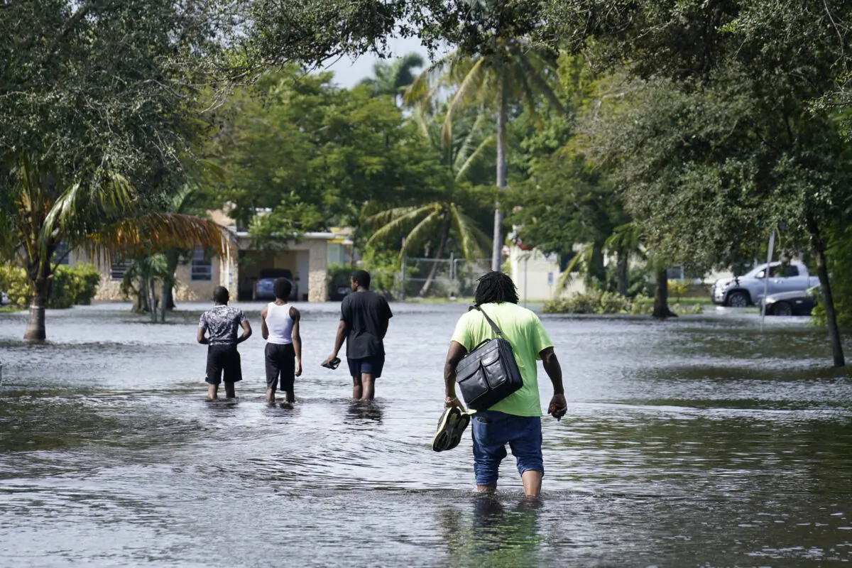Residents walk a flooded street to reach their homes, Nov. 9, 2020, in Fort Lauderdale, Fla. Tropical Storm Eta caused severe flooding in South Florida in areas already saturated from previous downpours. (AP Photo/Marta Lavandier)