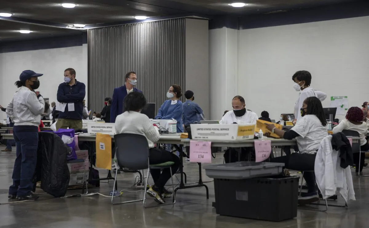 Poll challengers watch workers with the Detroit Department of Elections inspect and sort absentee ballots at the Central Counting Board in the TCF Center in Detroit, Mich., on Nov. 4, 2020. (Elaine Cromie/Getty Images)