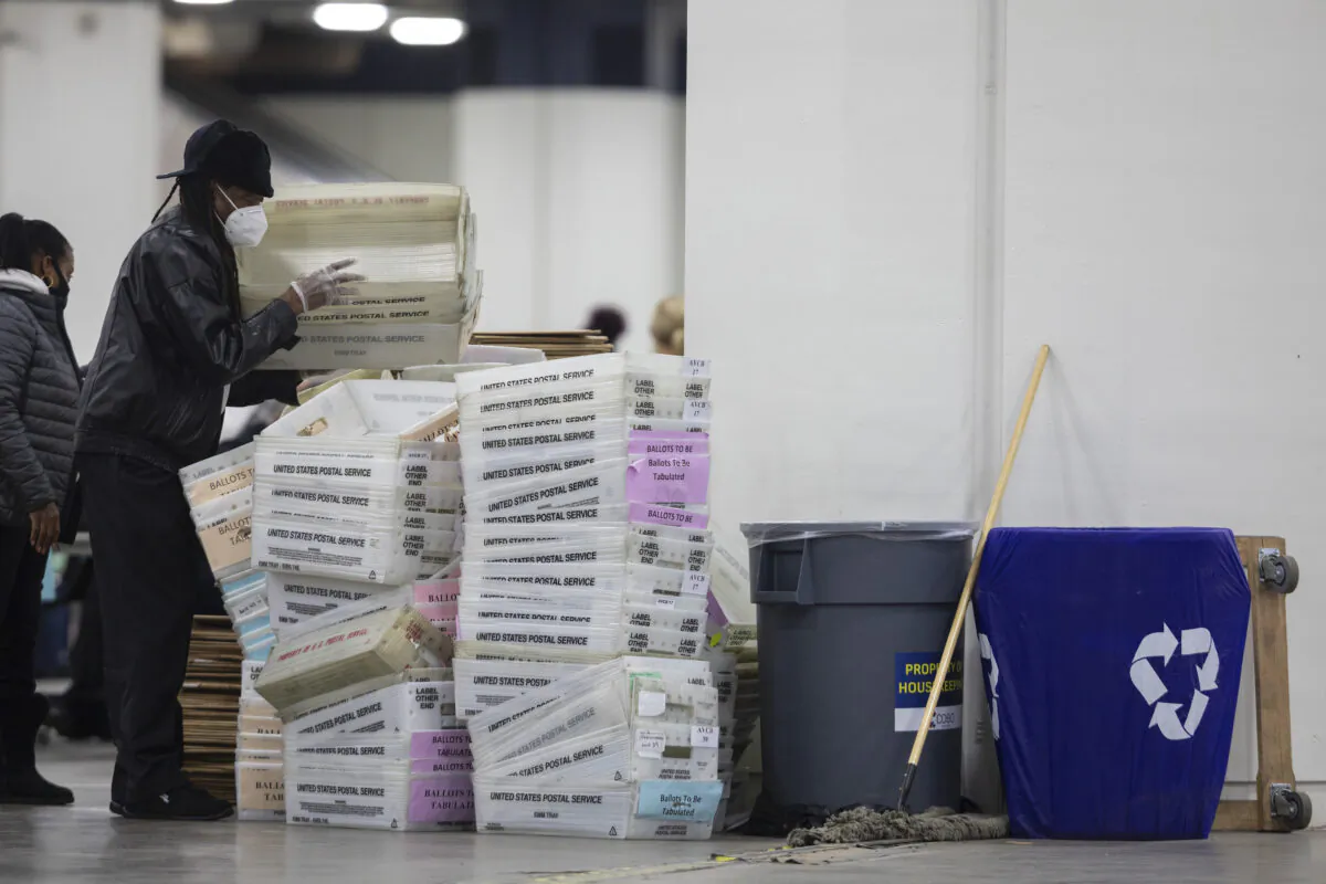 A worker with the Detroit Department of Elections helps stack empty boxes used to organize absentee ballots after nearing the end of the absentee ballot count at the Central Counting Board in the TCF Center in Detroit, Mich., on Nov. 4, 2020. (Elaine Cromie/Getty Images)