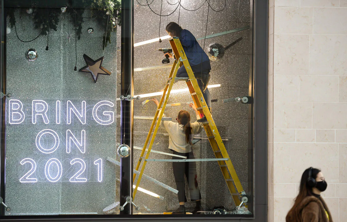 Workers install a festive Christmas-themed window display in a Harvey Nichols store in central Manchester, northwest England, on Nov. 4, 2020. (Oli Scarff/AFP via Getty Images)