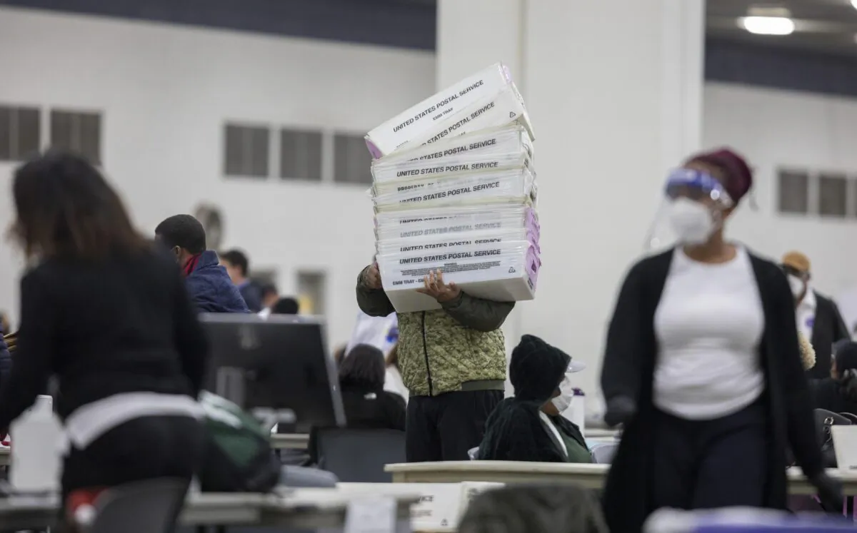 A worker with the Detroit Department of Elections carries empty boxes used to organize absentee ballots after nearing the end of the absentee ballot count at the Central Counting Board in the TCF Center in Detroit, Mich., on Nov. 4, 2020. (Elaine Cromie/Getty Images)