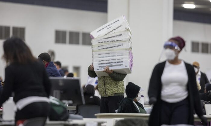 A worker with the Detroit Department of Elections carries empty boxes used to organize absentee ballots after nearing the end of the absentee ballot count at the Central Counting Board in the TCF Center in Detroit, Mich., on Nov. 4, 2020. (Elaine Cromie/Getty Images)