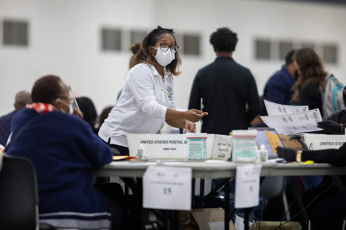 A worker with the Detroit Department of Elections reaches for an absentee ballot at the Central Counting Board in the TCF Center in Detroit, Mich., on Nov. 4, 2020. (Elaine Cromie/Getty Images)
