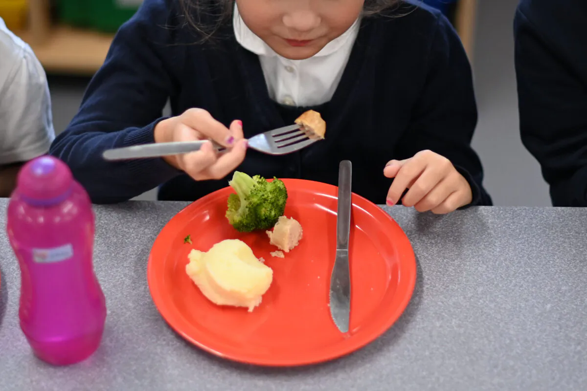 A pupil eats her cooked hot dinner during her lunch break in the canteen at St. Luke's Church of England Primary School in east London, on Sept. 3, 2020. (Daniel Leal-Olivas/AFP via Getty Images)