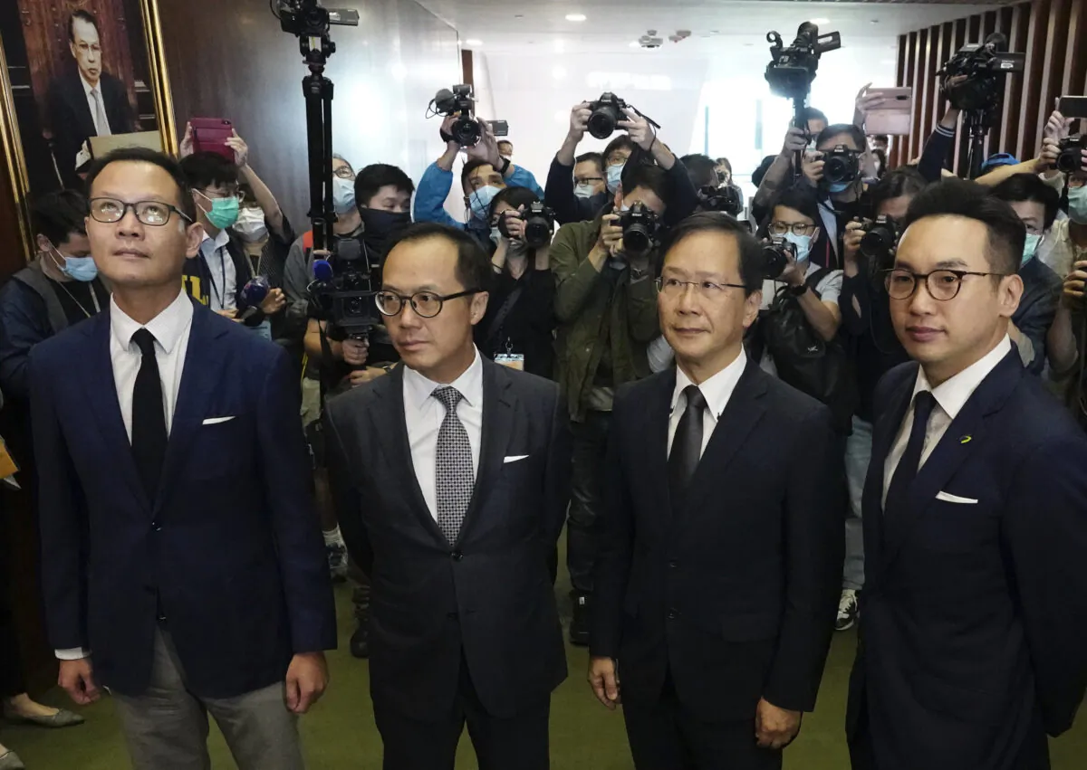 Hong Kong has moved to disqualify four pro-democracy legislators, after Beijing passed a resolution that would allow the local government to remove lawmakers from their positions if they're deemed to threaten national security. The four lawmakers, Dennis Kwok (L), Kenneth Leung (2nd L), Kwok Ka-ki (2nd R) and Alvin Yeung (R) pose after a news conference at Legislative Council in Hong Kong, on Nov. 11, 2020. (Vincent Yu/The Associated Press)