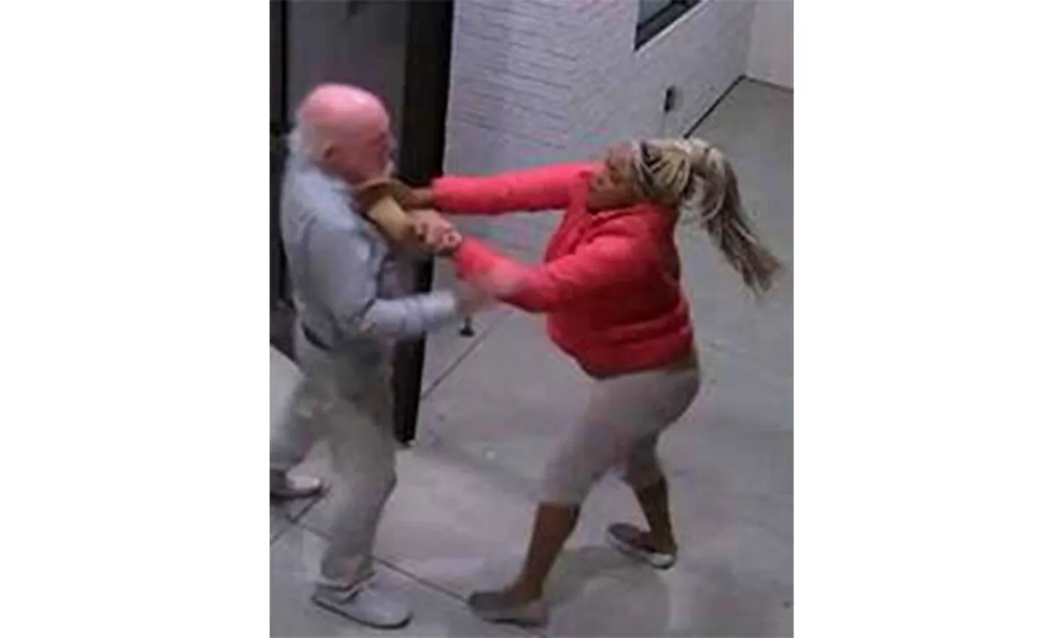A screenshot taken from surveillance video shows a woman attacking a man outside an apartment building in Santa Ana, Calif., on Oct. 21, 2020. (Courtesy of the Santa Ana Police Department)