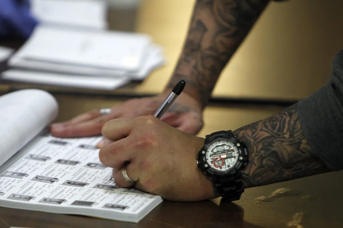 An inmate signs before casting his ballot during an early vote during the referendum for Puerto Rico political status at a prison in Bayamon on June 9, 2017.
(Ricardo Arduengo/AFP via Getty Images)