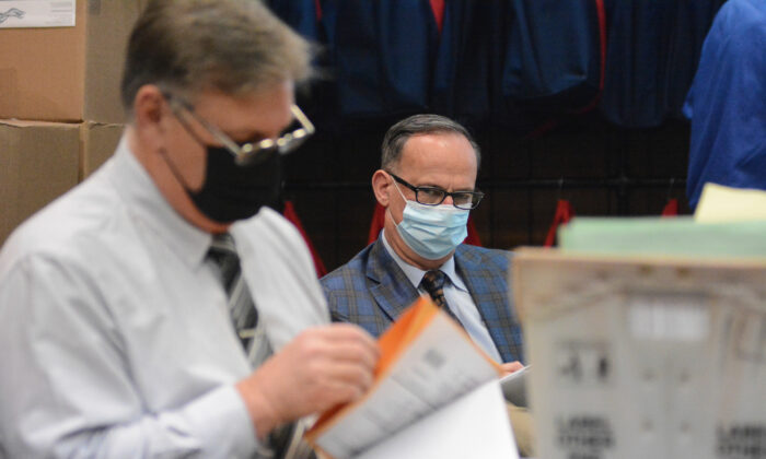 Democrat poll watcher Edward Brennan, center, observes Election Bureau Director Albert L. Gricoski, left, open provisional ballots at the Schuylkill County Election Bureau in Pottsville, Penn. on Nov. 10, 2020. (Lindsey Shuey/The Republican-Herald via AP)