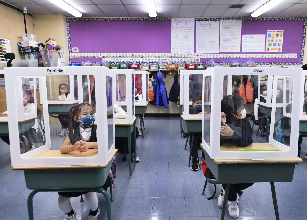 Children sit at their desks behind screened cubicles in their classroom at St. Barnabas Catholic School in Scarborough, Ont., on Oct. 27, 2020. (The Canadian Press/Nathan Denette)