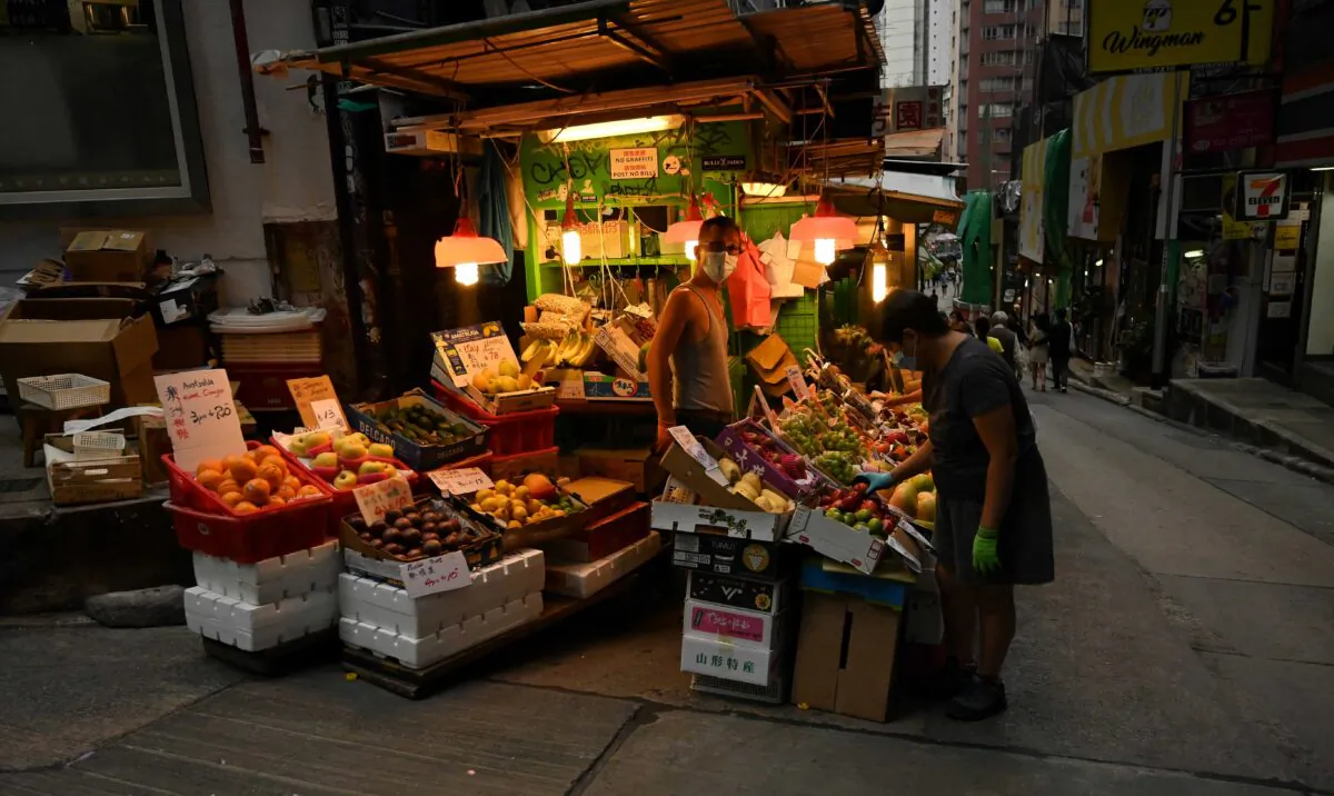 A fruit vendor waits for customers along a street in Hong Kong on Nov. 14, 2020. (Peter Parks/AFP via Getty Images)