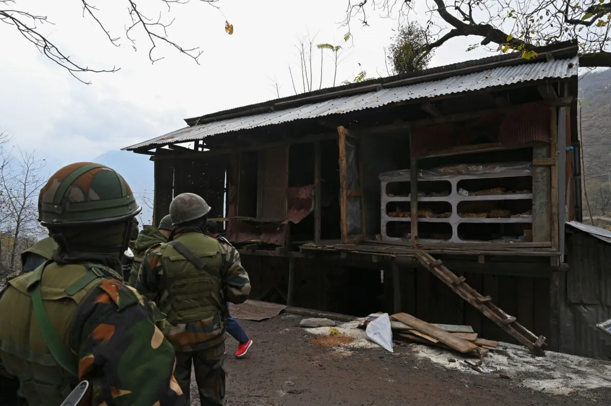 Indian army soldiers inspect shops damaged during Pakistani cross-border shelling at Sultan Daki village near the Line of Control (LOC), the defacto border between Pakistan and India, at Uri some 135 Kms east of Srinagar, on Nov. 14, 2020. (Tauseef Mustafa/AFP via Getty Images)