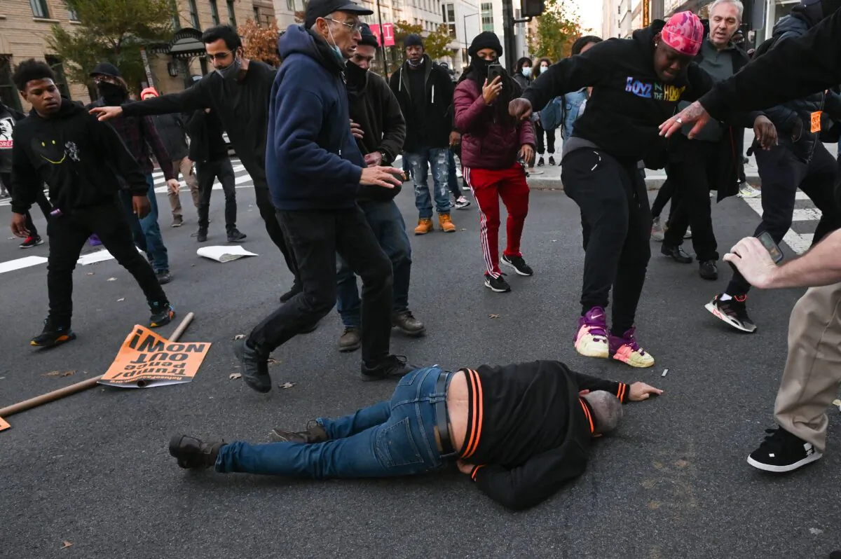 A supporter of President Donald Trump is kicked in the head by an anti-Trump protestor, after being sucker punched by another, in Washington on Nov. 14, 2020. (Roberto Schmidt/AFP via Getty Images)