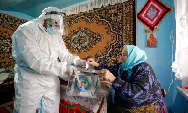 Moldovan election official wearing a biohazard suit