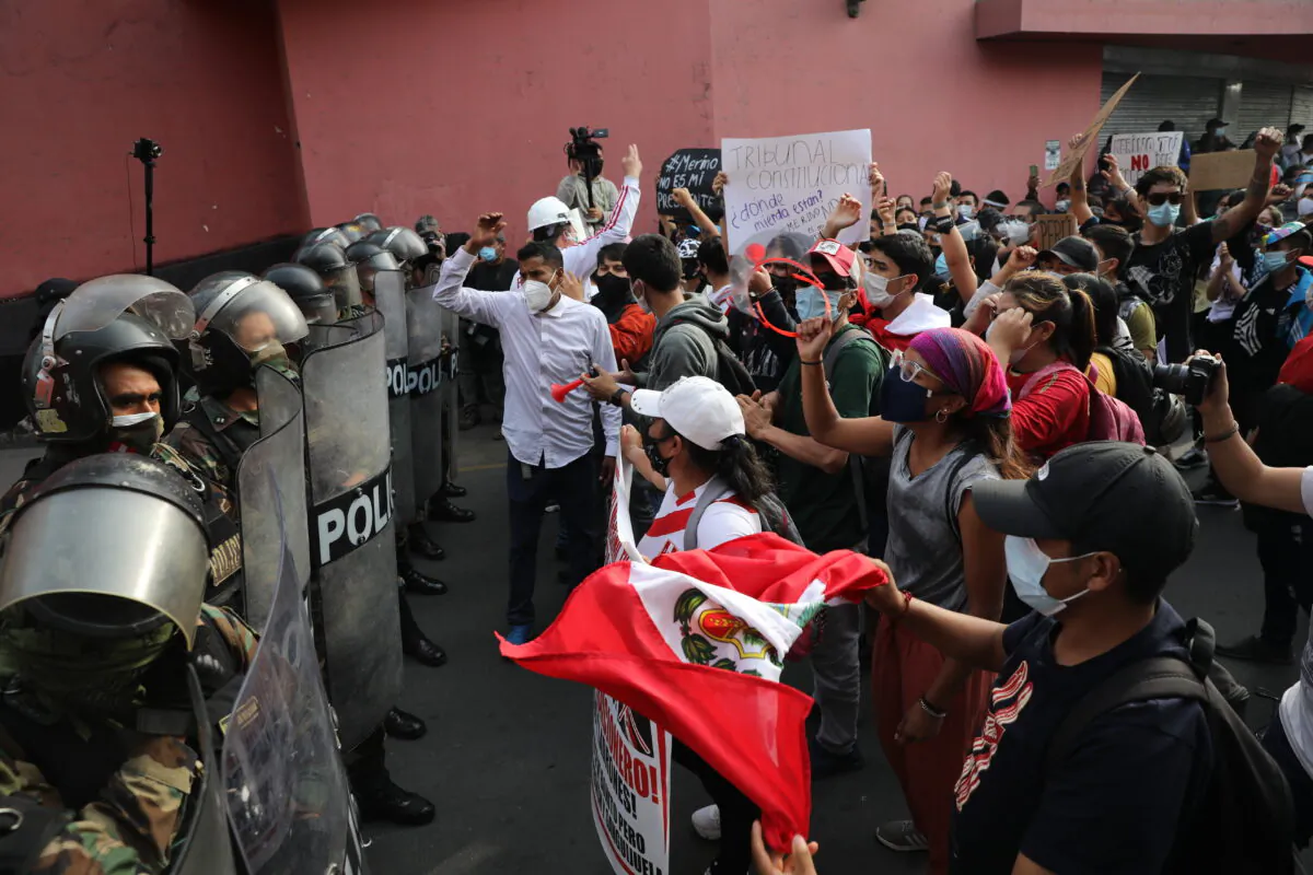 Supporters of ousted Peruvian President Martin Vizcarra shout at police to let them pass as they try to march to Congress in Lima, Peru, on Nov. 11, 2020. (AP Photo/Rodrigo Abd)