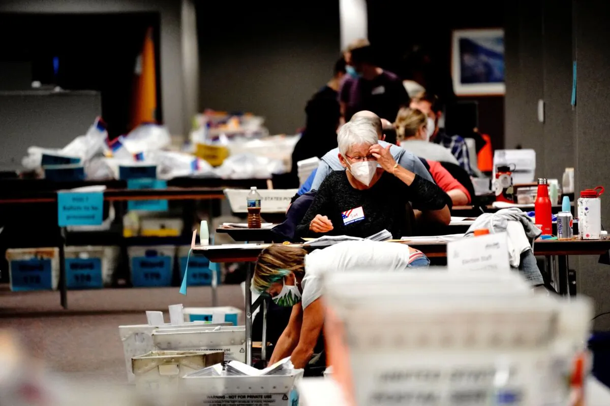 A poll worker gestures while processing absentee ballots at the Milwaukee Central Count the night of Election Day in Milwaukee, on Nov. 3, 2020. (Bing Guan/Reuters)