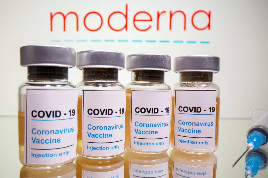 Vials with a sticker reading "COVID-19/Coronavirus vaccine/Injection only" and a syringe are seen in front of a displayed Moderna logo in this illustration taken on Oct. 31, 2020. (Reuters/Dado Ruvic)