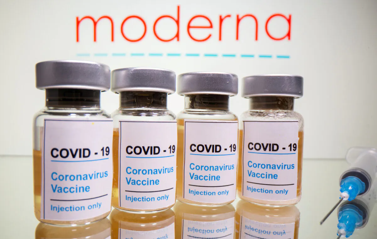 Vials with a sticker reading "COVID-19/Coronavirus vaccine/Injection only" and a syringe are seen in front of a displayed Moderna logo in this illustration taken October 31, 2020. (Reuters/Dado Ruvic/Illustration/File Photo)