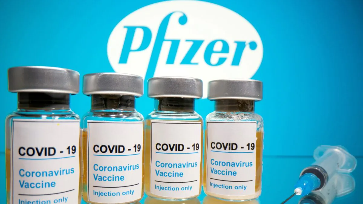 Vials of coronavirus vaccine and a medical syringe are seen in front of a displayed Pfizer logo, on Oct. 31, 2020. (Dado Ruvic/Reuters)