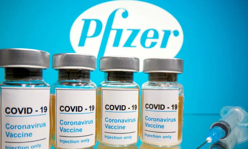 Vials of the CCP virus vaccine and a medical syringe are seen in front of a displayed Pfizer logo on Oct. 31, 2020. (Dado Ruvic/Reuters)