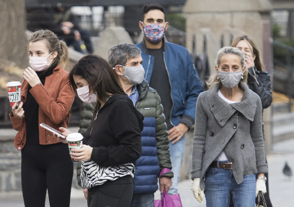 People wear face masks as they walk along a street in Montreal on Nov. 7, 2020, as the COVID-19 pandemic picks up steam. (The Canadian Press/Graham Hughes)