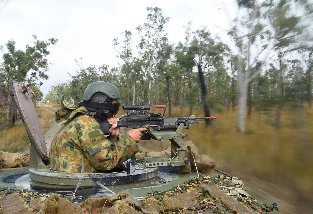 An Australian soldier operates a machine gun on the top turret of a Bushmater amoured vehical as part of exercise Talisman Sabre  in Rockhampton, Australia on July 9, 2015. (Ian Hitchcock/Getty Images)