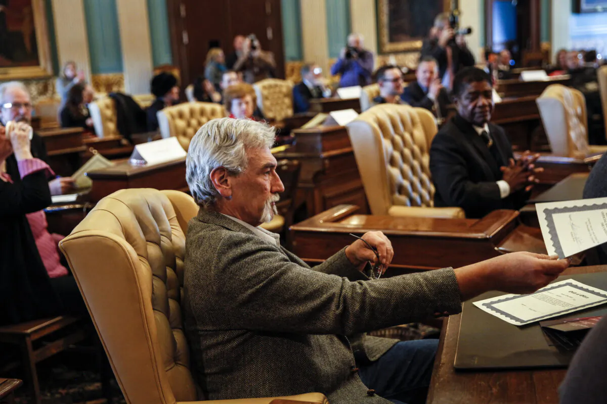 Robert Weitt, a Michigan representative to the electoral college, hands in his signed vote for President-elect Donald Trump at the Michigan State Capitol in Lansing, Mich., on Dec. 19, 2016. (Sarah Rice/Getty Images)